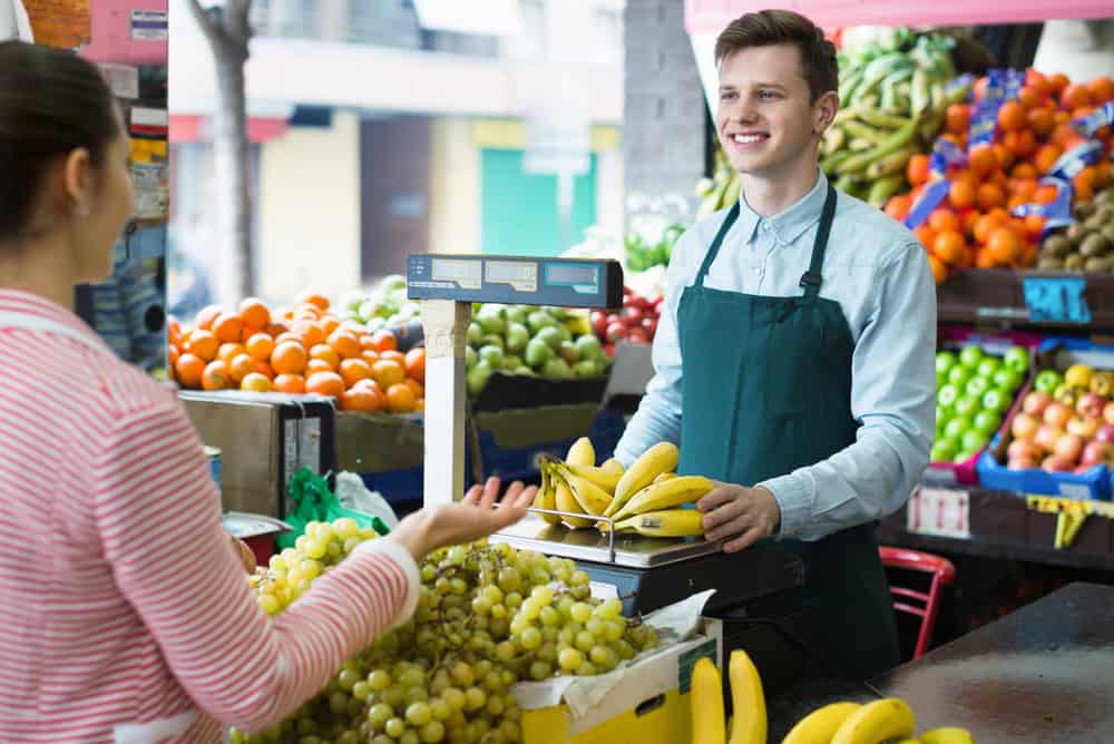 Beautiful,Woman,Customer,Buying,Yellow,Bananas,In,Supermarket,And,Smiling